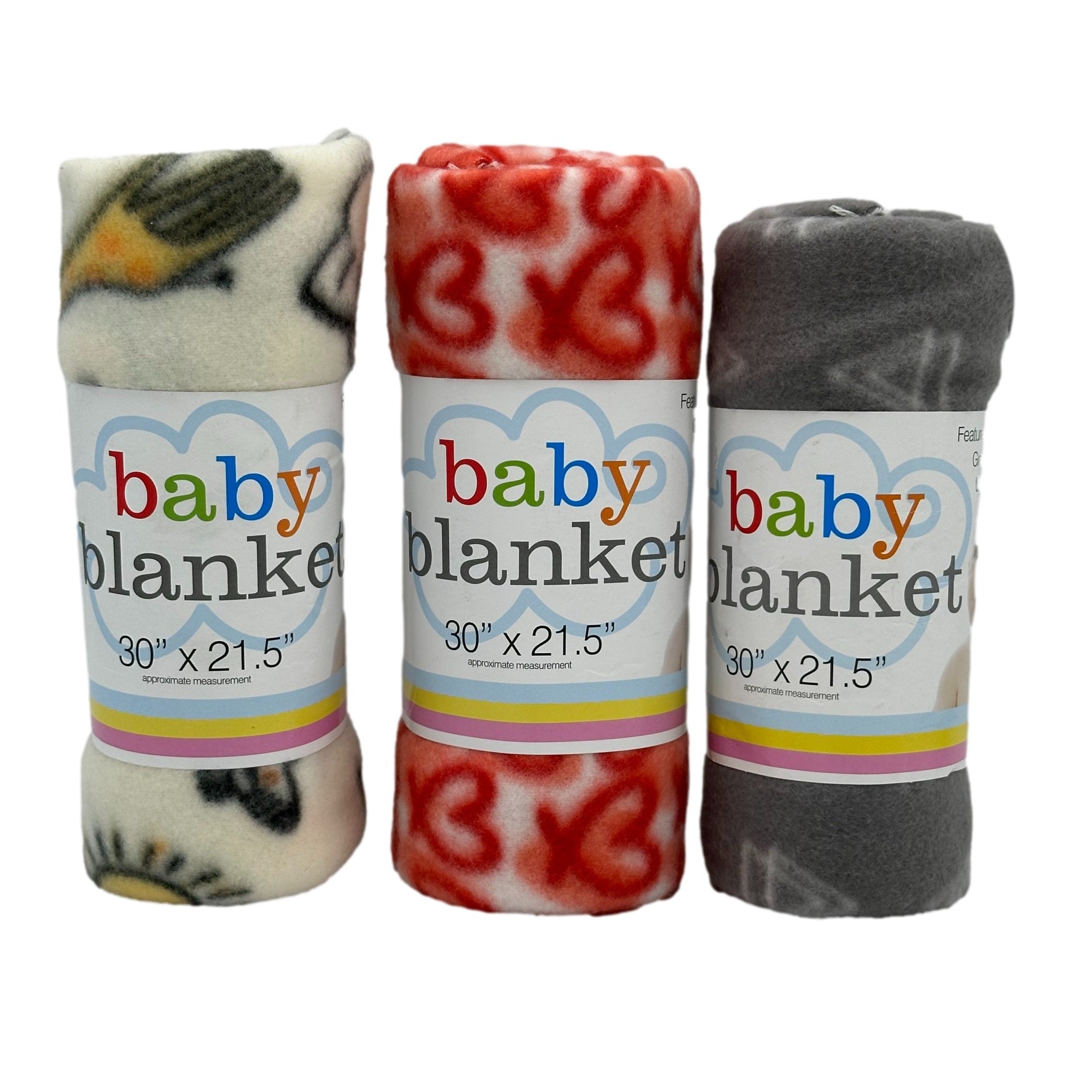 Three rolled baby blankets, each wrapped with a labeled paper band. One is off-white with a pattern, another is red and white with hearts, and the last is gray with white.